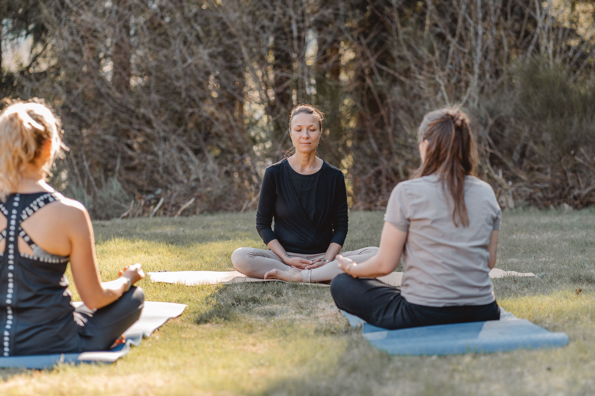 „Elena Dorner sitzt ruhig in Meditation während eines Yoga Retreats und nimmt sich bewusst Zeit für Selbstfürsorge und innere Ruhe“