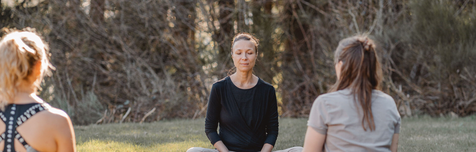 „Elena Dorner sitzt ruhig in Meditation während eines Yoga Retreats und nimmt sich bewusst Zeit für Selbstfürsorge und innere Ruhe“