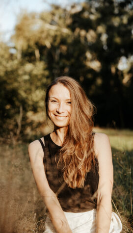 Elena, Spiritual Life Coach und Yogalehrerin, sitzt ruhig und lächelnd vor einem hellen Hintergrund. Sie steht für Achtsamkeit, Selbstliebe und ganzheitliche Begleitung mit Yoga, Meditation und Coaching.