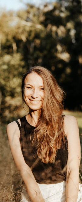 Elena, Spiritual Life Coach und Yogalehrerin, sitzt ruhig und lächelnd vor einem hellen Hintergrund. Sie steht für Achtsamkeit, Selbstliebe und ganzheitliche Begleitung mit Yoga, Meditation und Coaching.